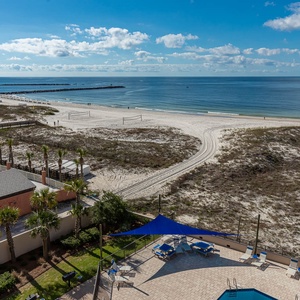 Gaze at the serene waters while lounging by the pool, surrounded by lush greenery and stunning beach views