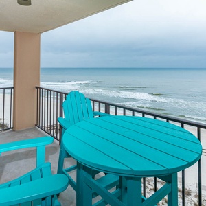 Relax on the eighth floor balcony with coastal furniture while enjoying the serene beach view and gentle waves