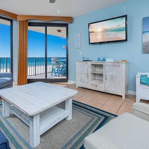 Relax in the inviting living area with comfortable seating and stunning beach views through large windows