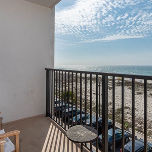 This balcony offers a serene view of the beach with comfortable seating for relaxation