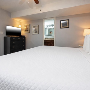 Cozy bedroom featuring a plush king bed, modern decor, and a flat-screen TV, perfect for a relaxing getaway