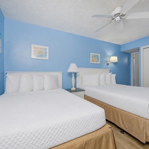 Two queen beds in your guest suite offer restful nights surrounded by calming coastal decor and soft lighting