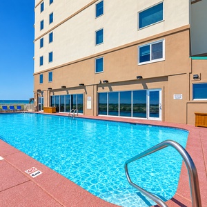 Relax in the beachfront pool at Royal Palms with stunning views and palm trees, perfect for unwinding after a day of fun