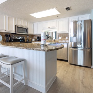 Gather around the sleek granite bar with seating, perfect for casual meals and conversations in this inviting kitchen