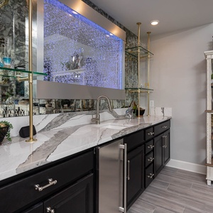 Enjoy a chilled drink from this elegant wet bar with stylish lighting and chic coastal accents