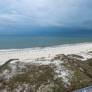 Gaze at the tranquil waters and arranged beach chairs, perfect for a relaxing day under the sky