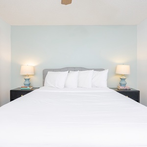 Enjoy restful nights in this inviting guest bedroom with a queen bed, soft linens, and coastal artwork