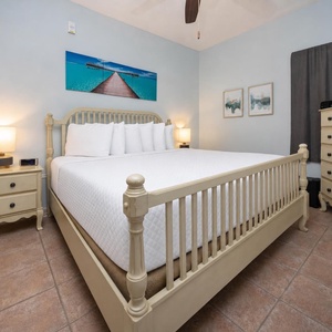 Brightly colored artwork complements the serene ambiance of this cozy bedroom featuring a king bed and a flat-screen TV