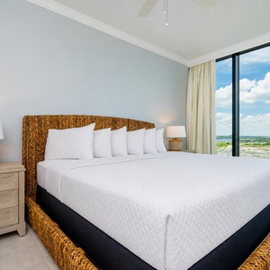 Relax in this inviting guest bedroom featuring a king bed, stylish decor, and large windows offering stunning views