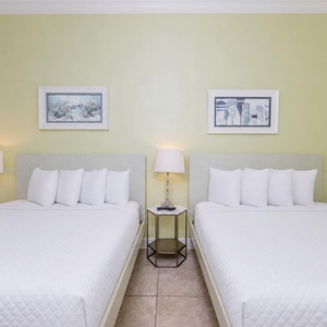 Rest comfortably in this serene guest room with two queen beds and soft lighting