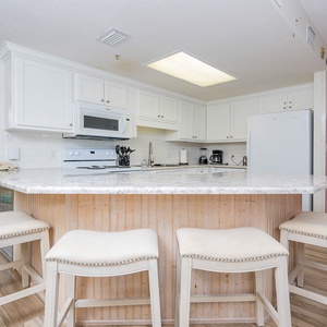Gather around the stylish kitchen breakfast bar, perfect for coffee and conversations in a welcoming space