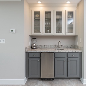 Craft refreshing drinks at the wet bar, enjoying easy access to glassware for memorable gatherings