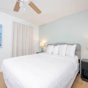 Relax in this inviting guest bedroom featuring a queen bed, soft linens, and coastal artwork for a tranquil stay