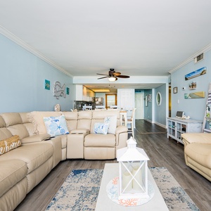 The living space features a light blue color scheme, comfortable seating, and a wall-mounted TV, perfect for relaxation
