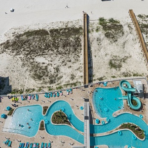 Discover the inviting pool area with gradual entry, a refreshing lazy river, and fun waterslide on the beach