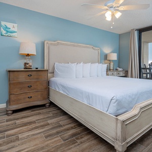 Relax in this serene master suite featuring a king bed, soft blue walls, and easy access to the beach balcony