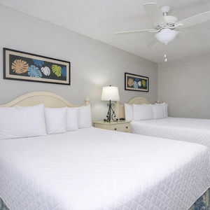 Sink into relaxing comfort in the guest room with two double beds, enjoying restful nights surrounded by coastal decor