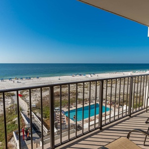 Enjoy stunning beachfront views from the balcony, complete with comfortable seating and a glimpse of the pool below