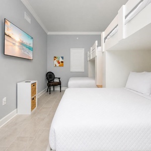 Cheerful guest room featuring two queen beds and lofted twin bunks for a restful retreat