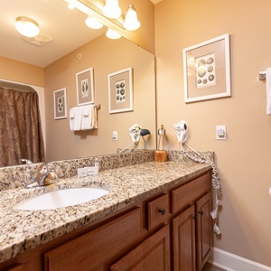 This bathroom features a stylish granite countertop, elegant decor, and a relaxing atmosphere for your daily routine