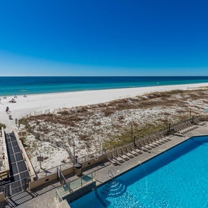 Gaze at the inviting pool area, just steps from the shore, with lounge chairs for relaxation under the sun