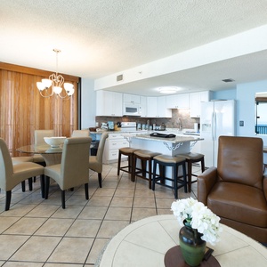 The fully-equipped kitchen features rich wood cabinetry, a breakfast bar with seating, and a stylish stone backsplash
