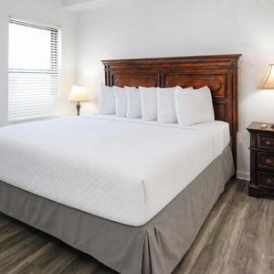 Guest bedroom featuring a plush king-size bed with decorative pillows and warm bedside lamps