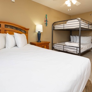 Guest bedroom featuring a wooden queen bed with plush pillows and a full bunk bed, perfect for family or group stays