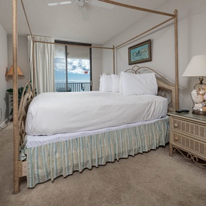 Drift off in the cozy master suite featuring a four-poster king bed, soft linens, and beachfront balcony