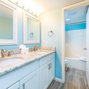 Two sinks and bright mirrors set the scene for getting ready in the master bath with calming blue walls