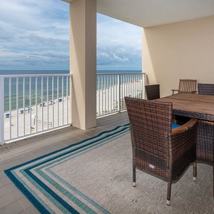 This inviting balcony features a dining set with a view of the beach, perfect for enjoying meals and sunsets