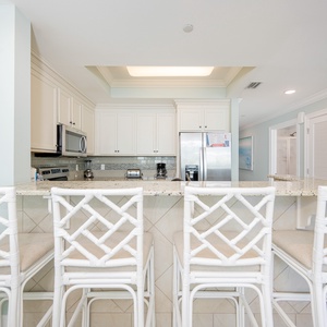 Gather around the inviting counter to sip morning coffee and share laughter in the airy kitchen space