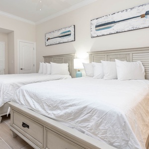 Rest in this guest room with two queens, read by the bedside lamp, and admire the oar artwork above the headboards