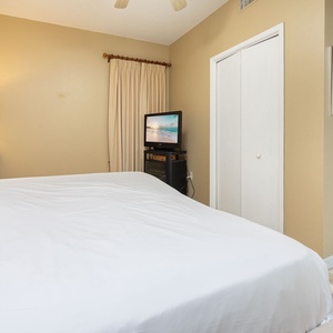 Relax in this comfortable bedroom featuring a king bed, TV, and a coastal vibe