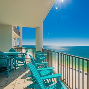 This balcony features bright turquoise chairs and a table, offering stunning beachfront views for relaxation and enjoyment