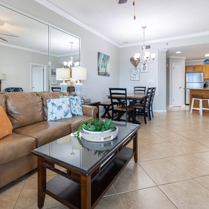 Cozy living area features a leather sofa with queen sleeper, a glass coffee table, and a dining space