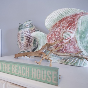 This charming decor features colorful fish sculptures and a welcoming sign, perfect for a beach-themed getaway