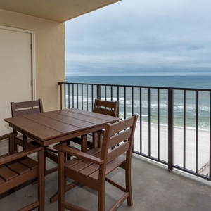 Relax on the private balcony with a stylish table and chairs, overlooking the tranquil waves and sandy shore