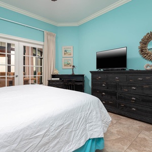 The master features a calming turquoise wall, a TV for entertainment, and convenient work desk area with complimentary WiFi