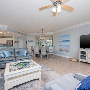 Unwind in the living space, where a gentle breeze and coastal decor invite relaxation and connection