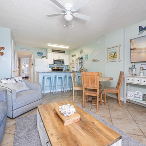 This cozy living area features a large TV, beach-themed decor, and a welcoming atmosphere perfect for relaxation