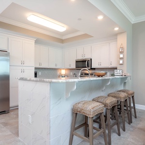 Experience the joy of preparing meals in this stylish kitchen, complete with cozy seating at the bar