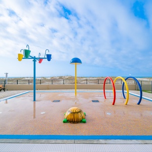 Enjoy the vibrant splash park area, perfect for family fun, with colorful play equipment and beach nearby