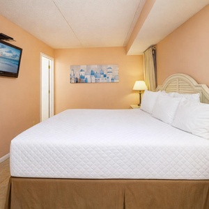 Drift into relaxation on the soft king bed, enjoying peace in the guest room adorned with soothing coastal decor