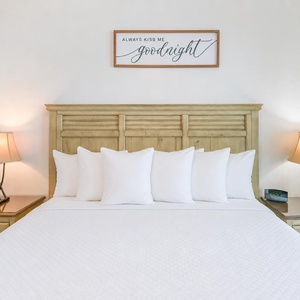 Drift into comfort on the plush king bed, where soft pillows invite restful nights and gently lit lamps create a warm vibe