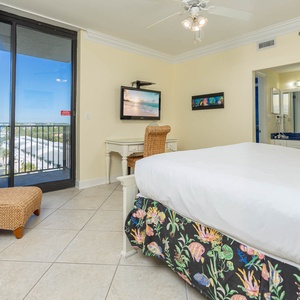 Cozy master bedroom features a plush king bed, a workspace with complementary WiFi, and a view of the balcony