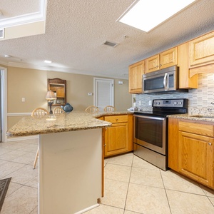 Prepare meals in the spacious kitchen featuring granite countertops, stainless appliances, and a breakfast bar