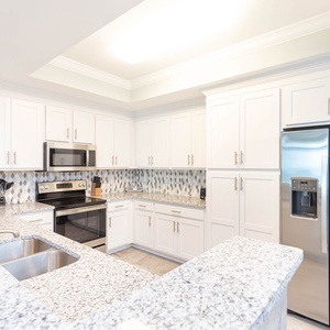 Prepare meals in this stylish kitchen with stainless appliances and admire the patterned backsplash