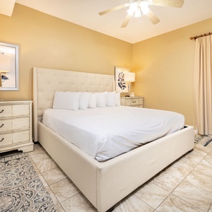 Serene bedroom featuring a plush king bed, soft lighting, and a TV for your entertainment