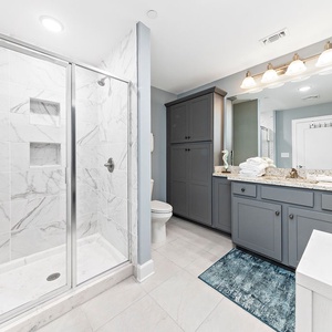 Enjoy a refreshing shower in this spacious guest bath with elegant tile accents and cabinetry